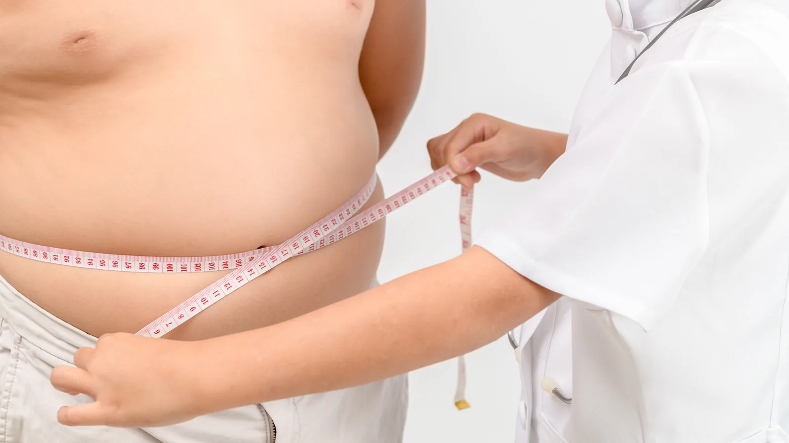 Clinician measuring a patient's waist with a tape
