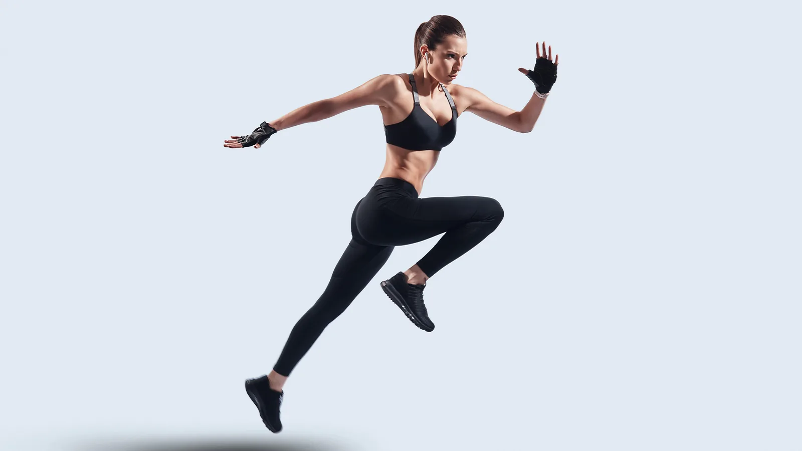 Athlete mid-stride in the air against a plain background