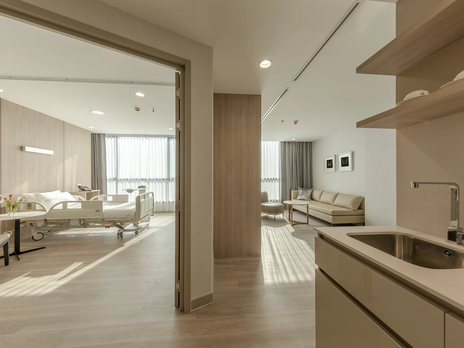ห้องพักฟื้นส่วนตัวพร้อมเตียงและมุมนั่งเล่นที่ YOUNIFY Clinic สีลม กรุงเทพฯ